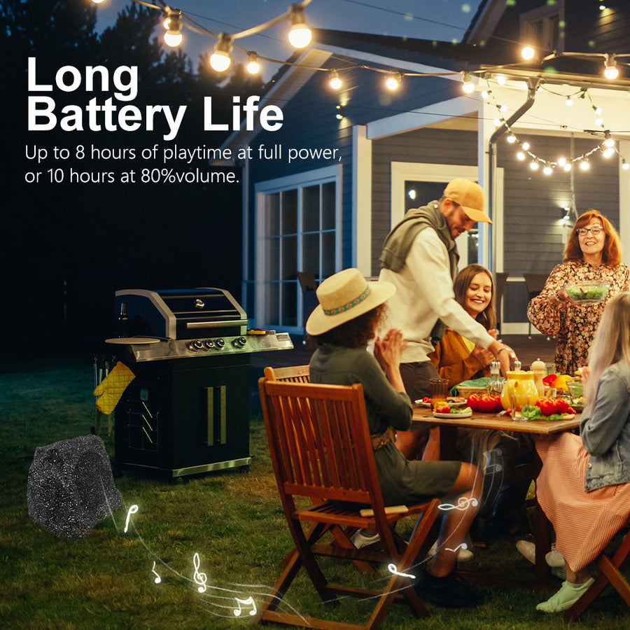 Herdio solar rock speaker playing at an outdoor patio gathering at night